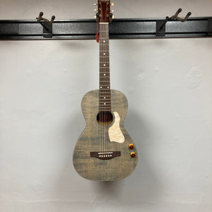 An Art & Lutherie Roadhouse Denim Blue Q-Discrete acoustic guitar hangs on a wall-mounted rack against a plain white background.