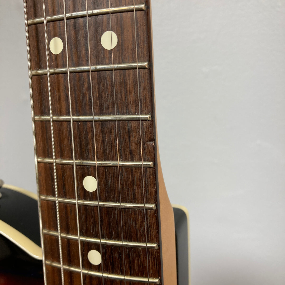 Close-up of a Fender Heritage '60s Telecaster Custom (Made in Japan, Sunburst) neck showing wood chipped along the fretboard edge near the fourth fret.