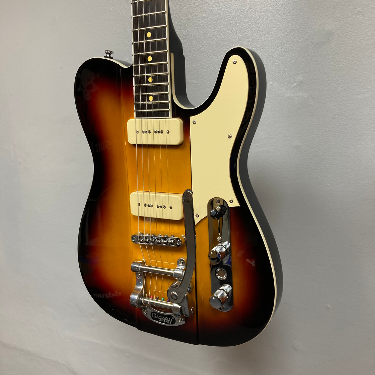 Reverend Greg Koch Signature Gristle 90 electric guitar in 3-Tone Burst with cream pickguard, Fishman Gristle 90 pickups, control knobs, Bigsby-style tremolo, and includes a gigbag.