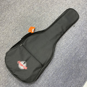 A black soft gigbag with a front zippered pocket and a "Haggleco" logo, perfect for your Reverend Greg Koch Signature Gristle 90 3-Tone Burst electric guitar, rests on a gray carpeted floor.