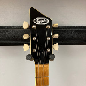 Close-up of the headstock of a Supro 1296 Silverwood British Racing Green w/Gigbag guitar by Supro, featuring six tuning pegs and mounted on a wall guitar holder.