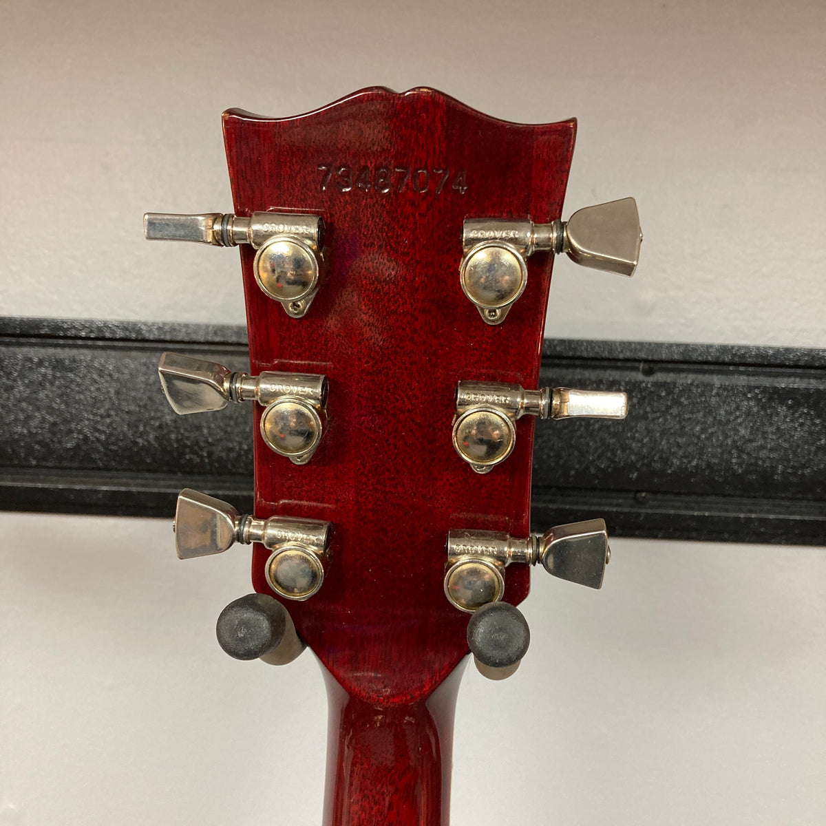 The back of the 1977 Gibson SG Standard Cherry w/Case headstock reveals six metal tuning pegs and a serial number stamped at the top, hallmarks of this classic Gibson model from the Kalamazoo era, renowned for its signature mahogany body construction.