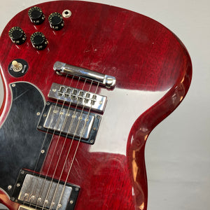 Close-up of a 1977 Gibson SG Standard Cherry electric guitar body by Gibson, featuring detailed views of its knobs, pickup selector switch, bridge, and pickups. The image accentuates the rich mahogany body craftsmanship characteristic of the esteemed Kalamazoo era, with the instrument set against a plain background.