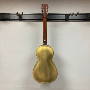 Back view of the Republic Parlor Resolian Antique Bronze Resonator w/Case by Republic, featuring a single cone design, displayed on a wall-mounted black guitar rack against a white wall.
