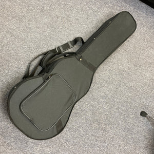 Republic Parlor Resolian Antique Bronze Resonator guitar in its soft black case, featuring a front pocket and shoulder strap, designed to fit this single cone parlor model by Republic, shown lying on a gray carpeted floor.
