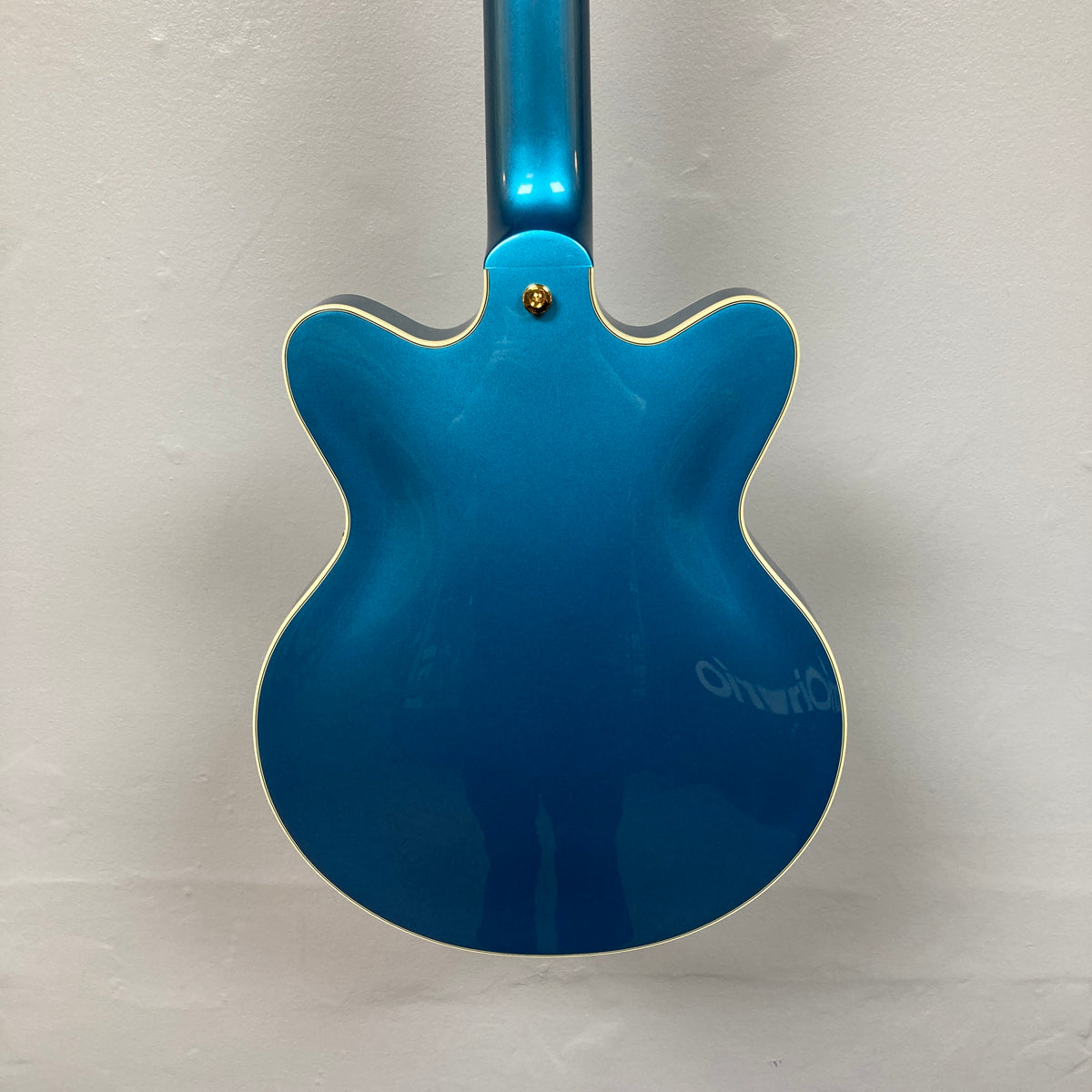 Back view of a Gretsch G2655TG Streamliner Riviera Blue Refurb semi-hollow electric guitar with cream-colored binding, set against a plain white wall.