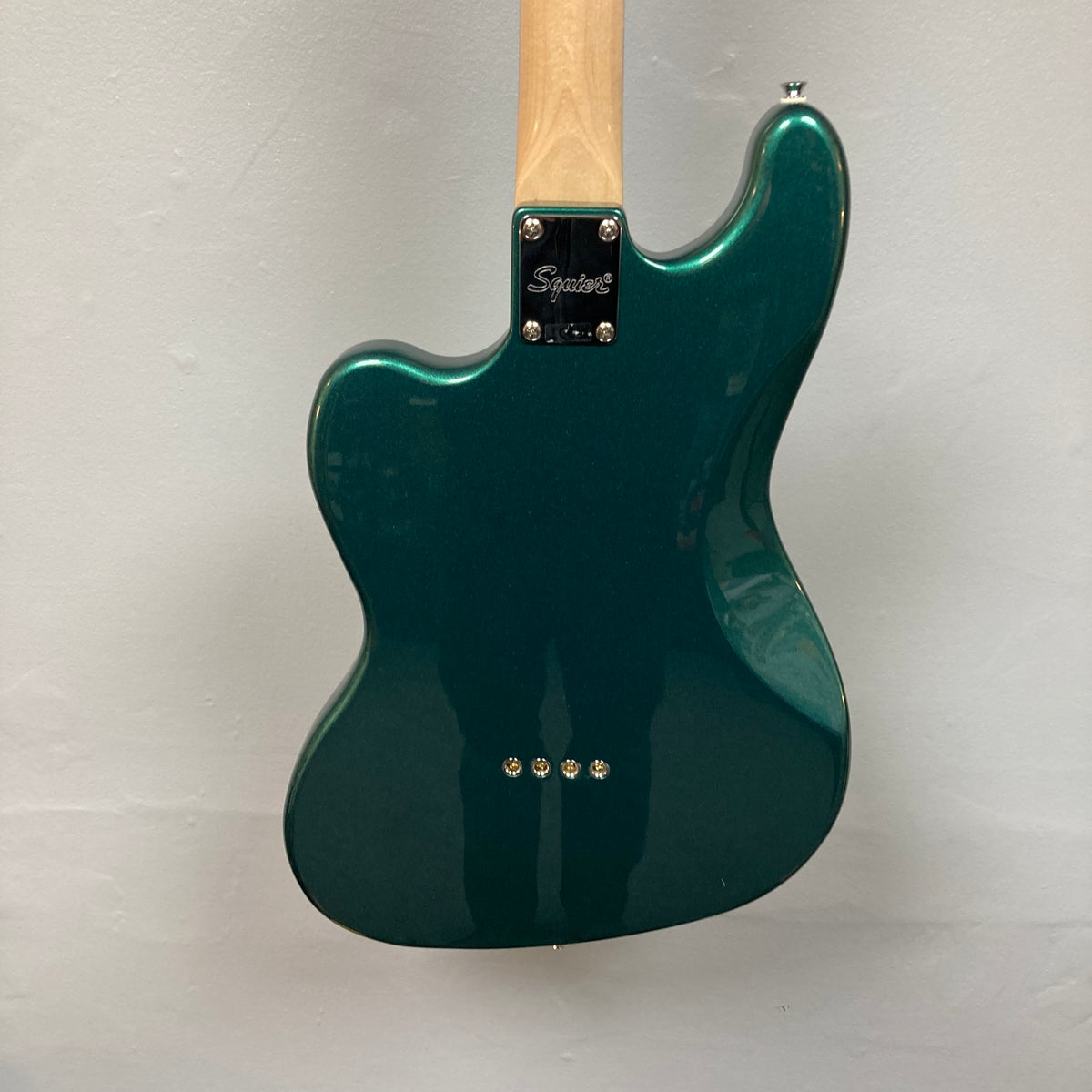 Back view of a Squier Paranormal Rascal Bass HH Sherwood Green Refurb, a short scale bass by Squier featuring a natural wood neck, metal neck plate stamped with “Squier,” and four visible screws on the body, shown against a plain light background.