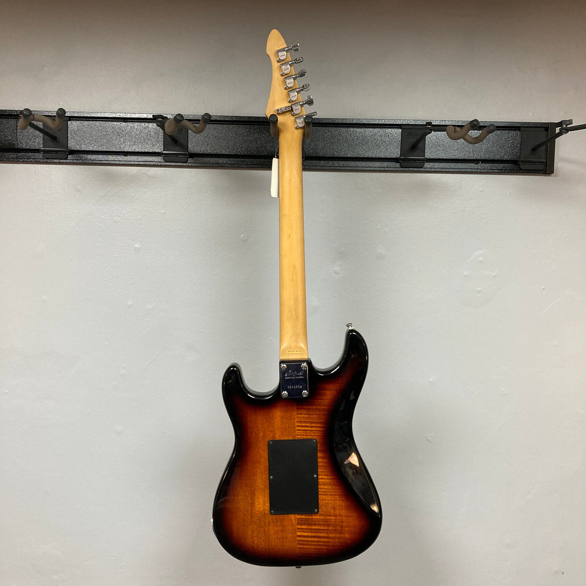 ARIA PRO II STG-02-3C electric guitar with visible humbucker-single-single pickups and Floyd Rose tremolo, mounted on a wall.
