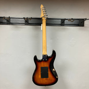 ARIA PRO II STG-02-3C electric guitar with visible humbucker-single-single pickups and Floyd Rose tremolo, mounted on a wall.