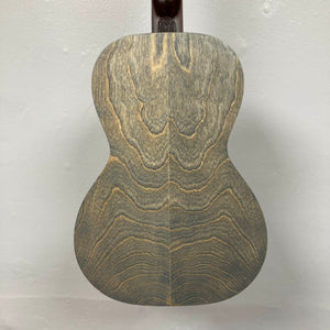 The back of the Art & Lutherie Roadhouse Denim Blue Q-Discrete Parlor Acoustic Guitar displays a wood grain pattern with wavy, symmetrical lines on a light-colored background.