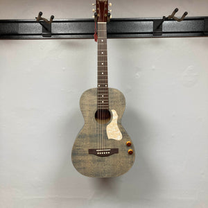 An Art & Lutherie Roadhouse Denim Blue Q-Discrete acoustic guitar hangs on a wall-mounted rack against a plain white background.