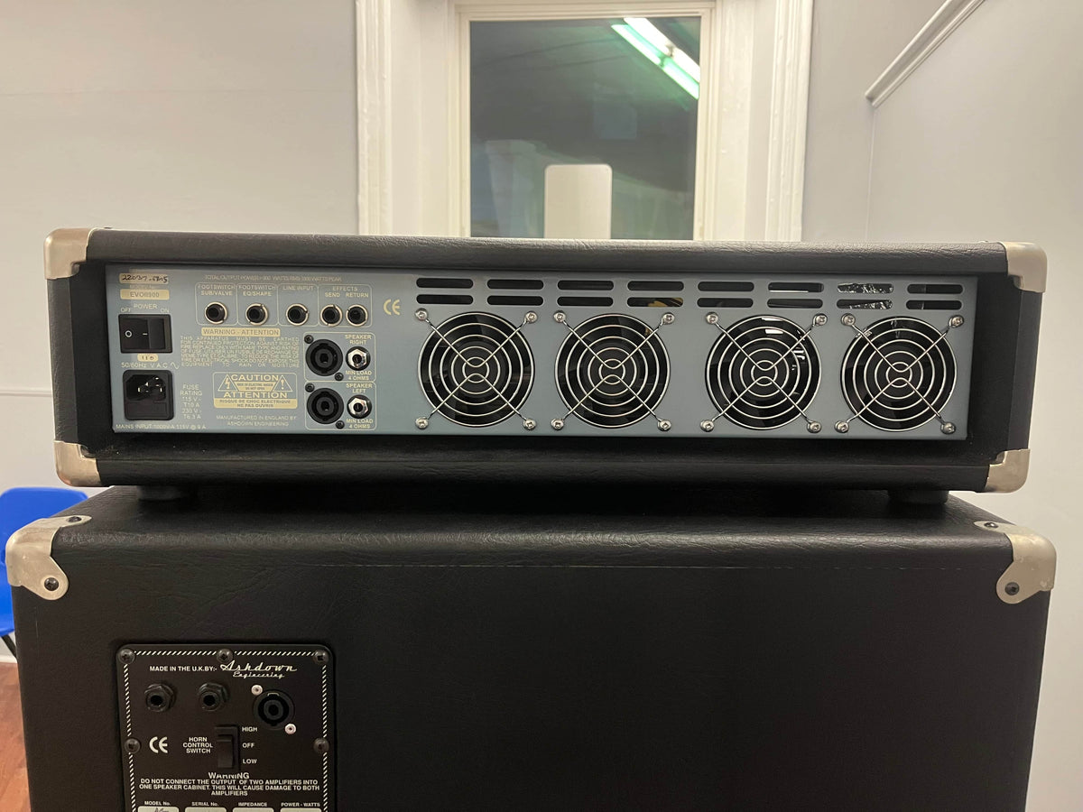 The rear panel of the Ashdown UK Built ABM Bass Rig Full Stack, featuring the EVO II 900 Head, displays cooling fans, I/O ports, switches, and a power socket on an Ashdown 410T and 115-500 bass cabinet.