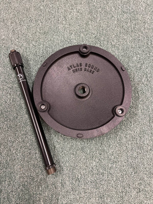 An Atlas Sound DMS10E Mic Stand Base with Extension Rod sits on a textured green surface.