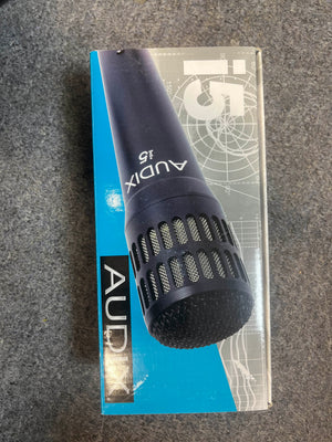 A box with the Audix i5 All-Purpose Dynamic Instrument Microphone (Preowned) by Audix is displayed on a grey surface.