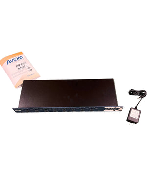 Aviom AN-16/i A-Net Input Module by Aviom, black rackmount, 16 channels, includes manual labeled "Aviom AN-16/i v.2" and power adapter on white background—ideal for pro live sound setups.