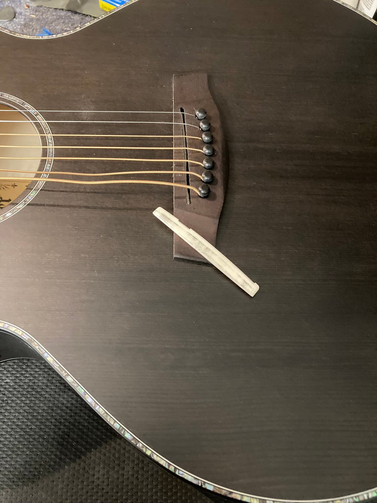 Basic Setup: Close-up of guitar strings and a pick on a wooden surface, highlighting essential components for guitar maintenance and play.