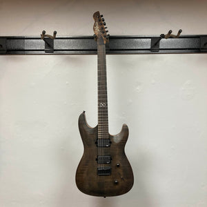 A Chapman ML1 Pro Modern Lunar electric guitar by Chapman, featuring a dark finish, 24 frets, and dual humbucker pickups, hangs on a wall-mounted guitar rack against a white background.