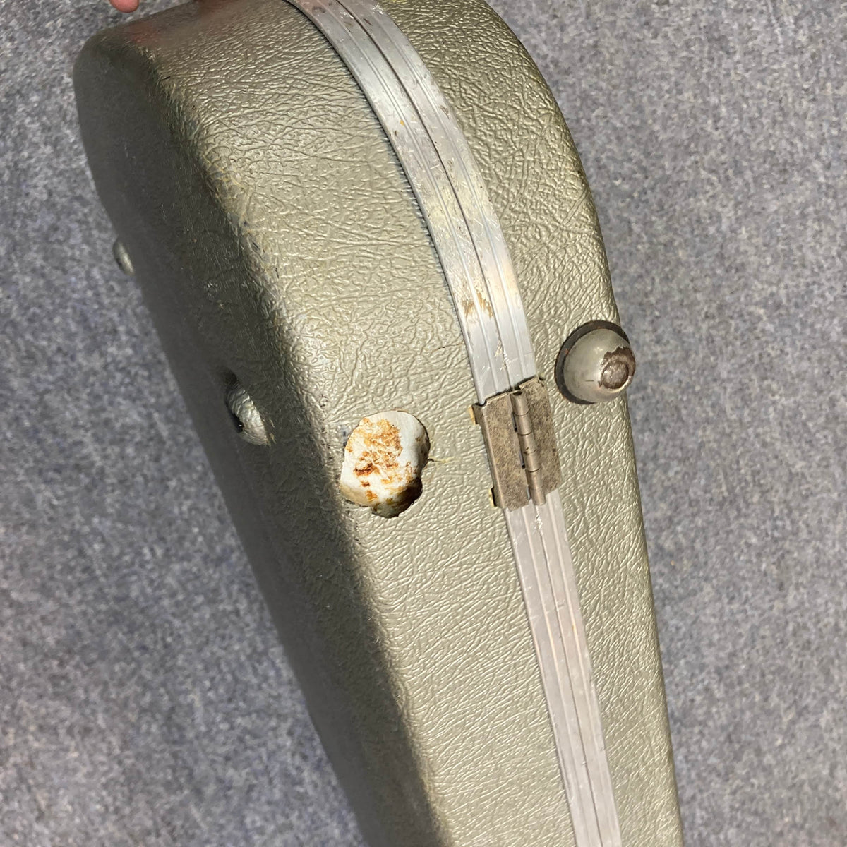 A Charvel Model 4 HSS Red electric guitar in its original hard shell case (OHSC) with a green textured finish, metal hinge, visible dents, and rust on the lid, displayed against a gray background.