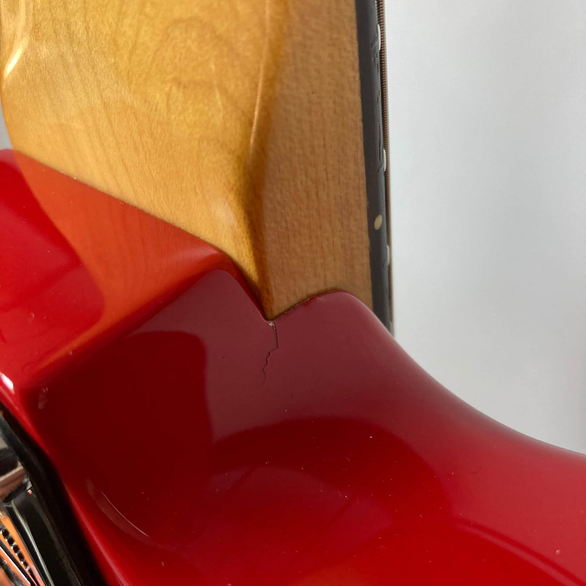 Close-up of a Charvel Model 4 HSS Red w/OHSC Consign by Charvel, highlighting a small crack at the neck-body joint.