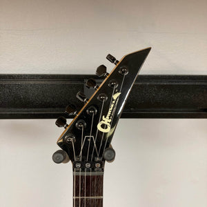 Close-up of the headstock of a Charvel Model 4 HSS Red w/OHSC Consign electric guitar by Charvel, featuring black tuning pegs and visible logo against a plain background.