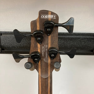 Close-up of a Cort Artisan B4 Element bass guitar, highlighting its roasted maple fretboard, Hipshot® Ultralite tuners, and ergonomic mahogany body.