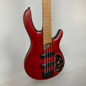 Cort Artisan B4 Element Burgundy Red electric bass guitar displayed on a wall, highlighting its craftsmanship and high-quality components.