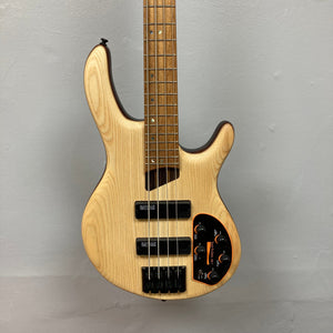 Cort Artisan B4 Element Natural - close-up of a wooden electric guitar with black knobs and strings, highlighting premium features and craftsmanship.