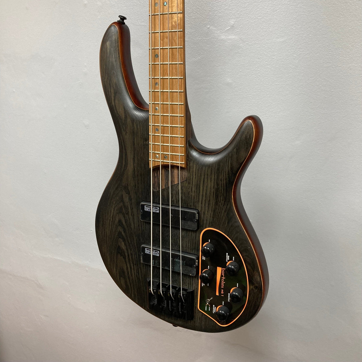 Cort Artisan B4 Element electric bass guitar with visible pickups and strings, featuring a 5-piece neck and black hardware.
