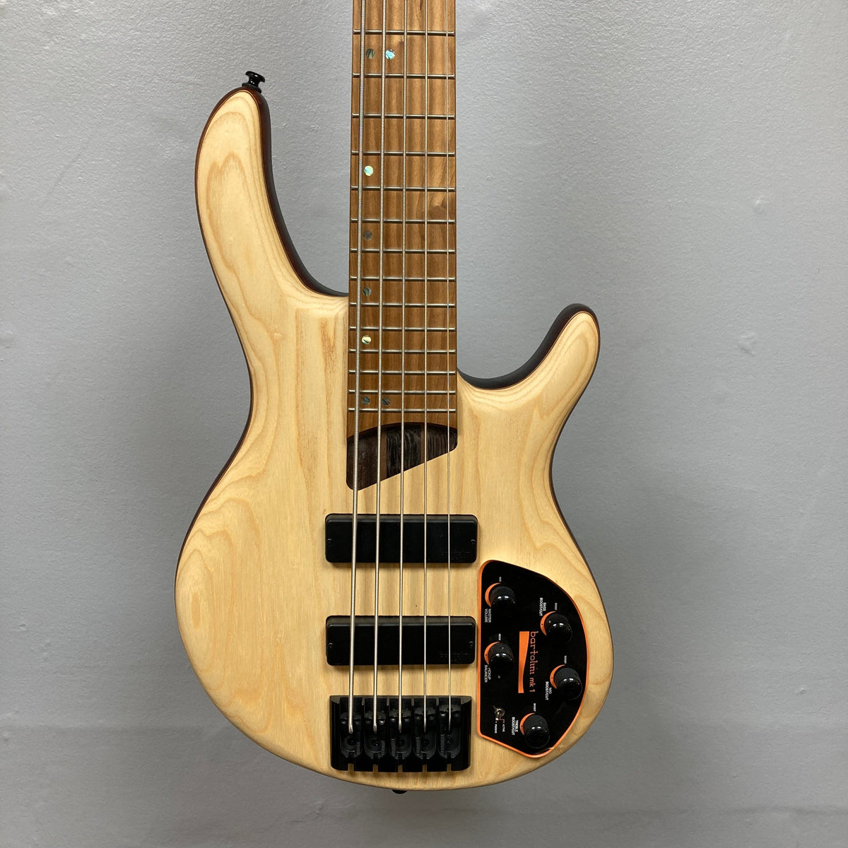 Cort Artisan B5 Element Natural Used bass guitar with close-up of strings and pickups, highlighting its craftsmanship and premium components for superior tone.