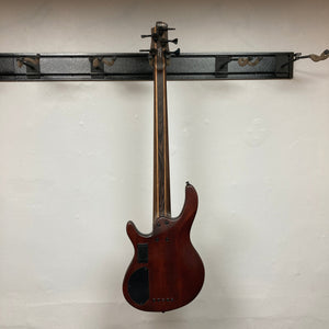 Cort Artisan B5 Element bass guitar on wall, showcasing Hipshot® tuners, roasted maple fretboard, and MetalCraft M5 bridges for enhanced tone.