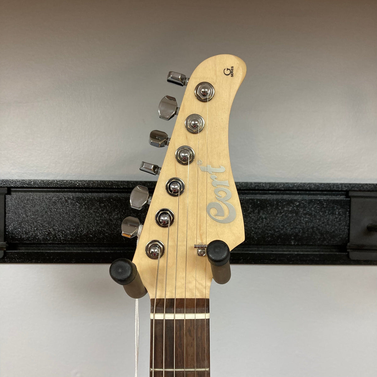 Cort G280 Select Amber on a stand showcasing its flamed maple top, Rosewood fingerboard, and Voiced Tone VTH-77 humbucker.