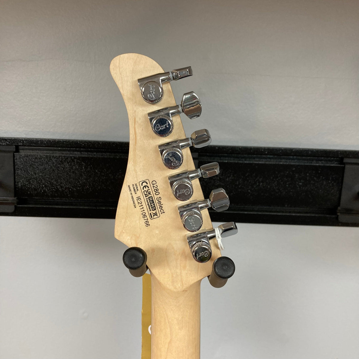 Close-up of the Cort G280 Select Amber guitar, highlighting its Pearloid pickguard, Rosewood fingerboard, and Voiced Tone VTH-77 hot humbucker with metal cover.