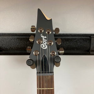 Cort KX300 EBR Etched Black Red guitar headstock and neck with metal tuning knobs and intricate wood grain details.