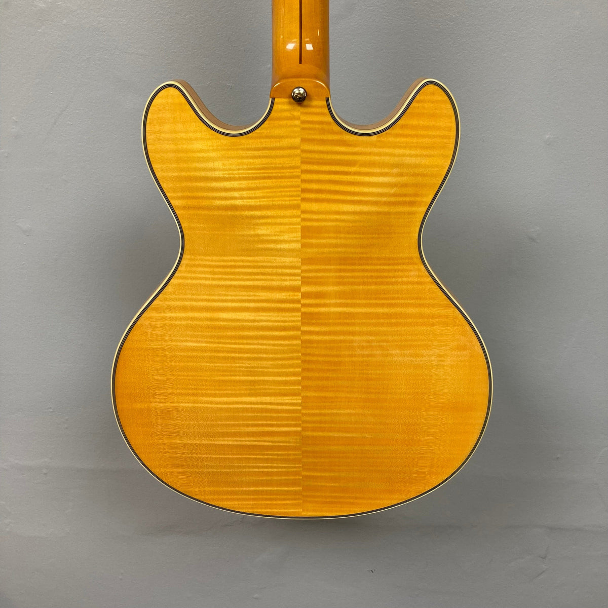 Close-up of the D'Angelico Excel DC Semi-hollowbody Vintage Natural guitar, showcasing its double-cutaway design and intricate craftsmanship.