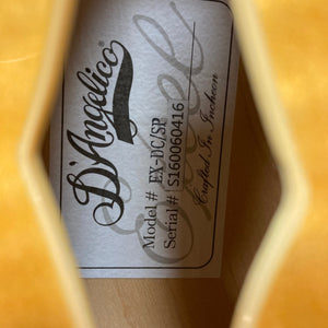 D'Angelico Excel DC Semi-hollowbody Vintage Natural guitar with visible label and intricate logo details.