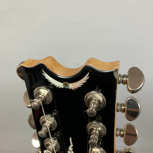 Close-up of a Dean Boca Trans Amber Burst 12 String headstock with twelve tuning pegs and an inlaid white bird design, ideal for fans of the semi hollow body guitar style. Includes gigbag.