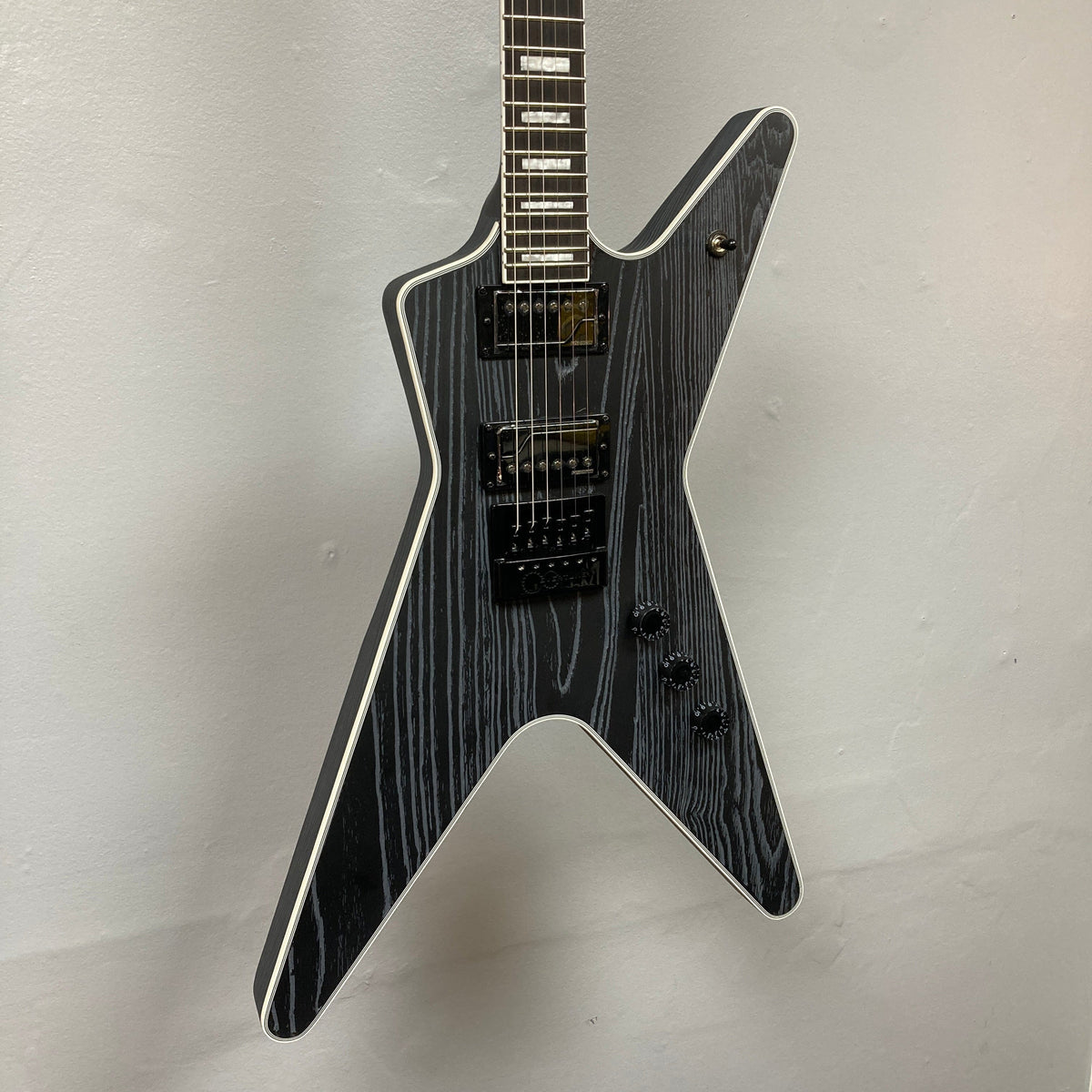 Dean Custom Run #16 ML Sandblasted Grey guitar on wall, showcasing strings and body design, limited edition model #37 of 100.