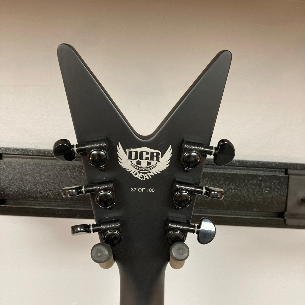 Dean Custom Run #16 ML guitar headstock, featuring white text and a sleek design, part of a limited edition sandblasted grey series, number 37 of 100.