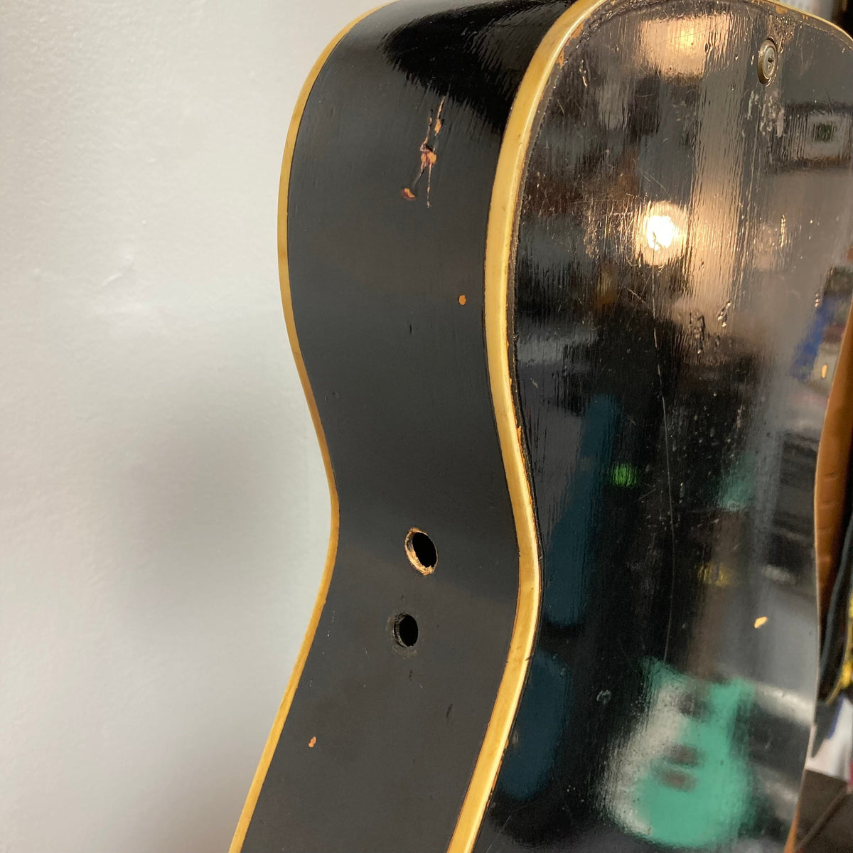 Close-up of a well-used Dobro Model 60 DS Round Neck resonator guitar with red burst finish, showcasing its distinct resonator and round neck design.