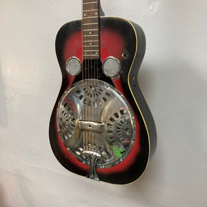 Dobro Model 60 DS Round Neck 1970s Red Burst resonator guitar, showcasing close-up of strings and metal resonator, highlighting its distinct traditional design and used condition.