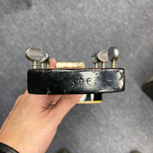 Hand gripping a Dobro Model 60 DS Round Neck 1970s Red Burst resonator guitar, showing silver knobs and metal details.