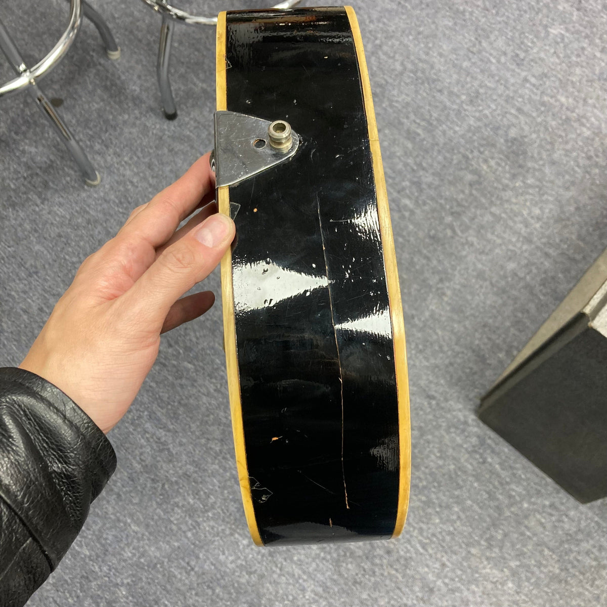 Hand holding a Dobro Model 60 DS Round Neck 1970s Red Burst resonator guitar.