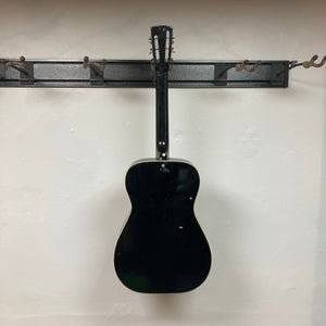 Dobro Model 60 DS Round Neck 1970s Red Burst resonator guitar, displayed on a wall, showcasing its traditional design and well-used condition.