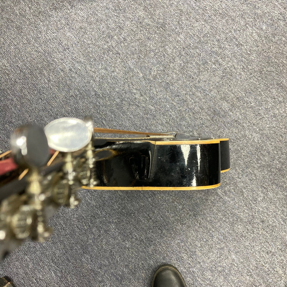 Dobro Model 60 DS Round Neck 1970s Red Burst resonator guitar on the floor, showcasing its well-used condition and distinctive design.