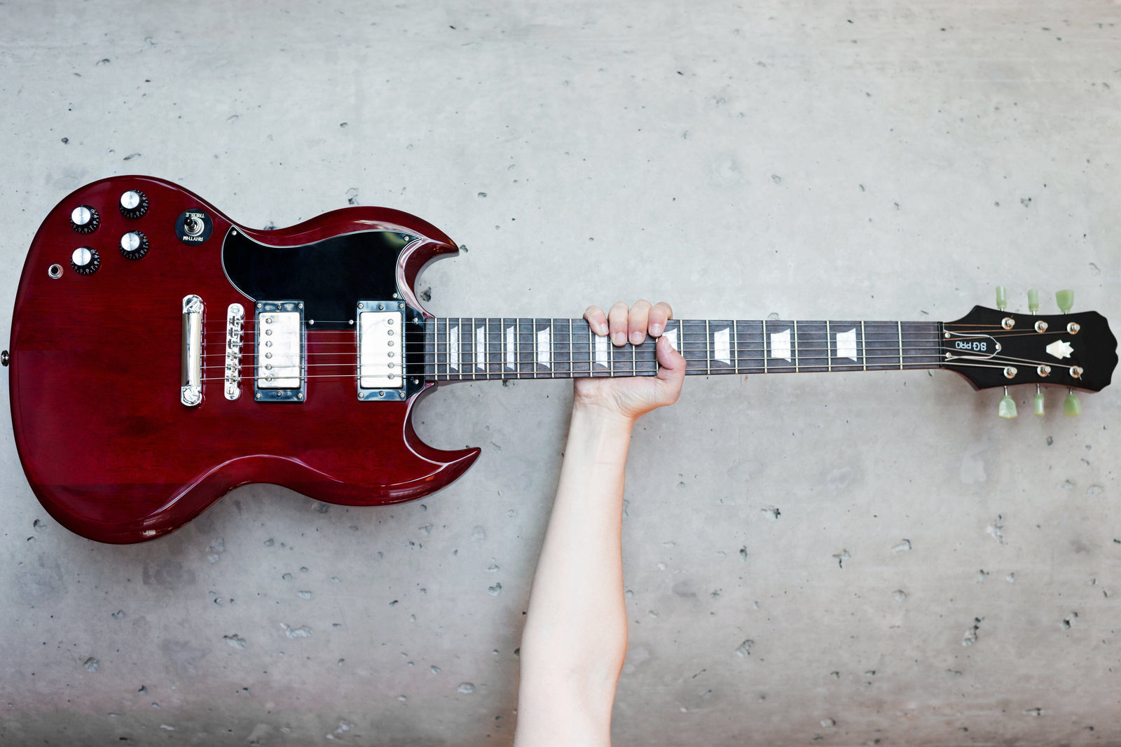 SG style guitar being held up straight up. SG style guitar being held up straight up.