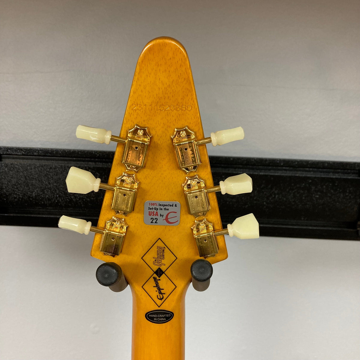 Epiphone 1958 Korina Flying V Left handed guitar, close-up showing strings, fretboard, and pickups, crafted by Gibson Custom Shop, includes hardshell case.