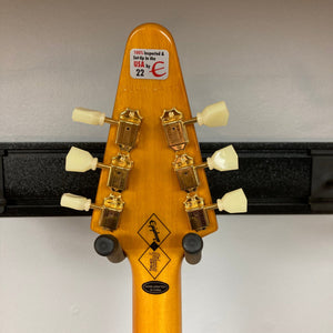 Epiphone 1958 Korina Flying V guitar close-up, showcasing vintage design with gold hardware and a solid Korina body, including a hardshell case.