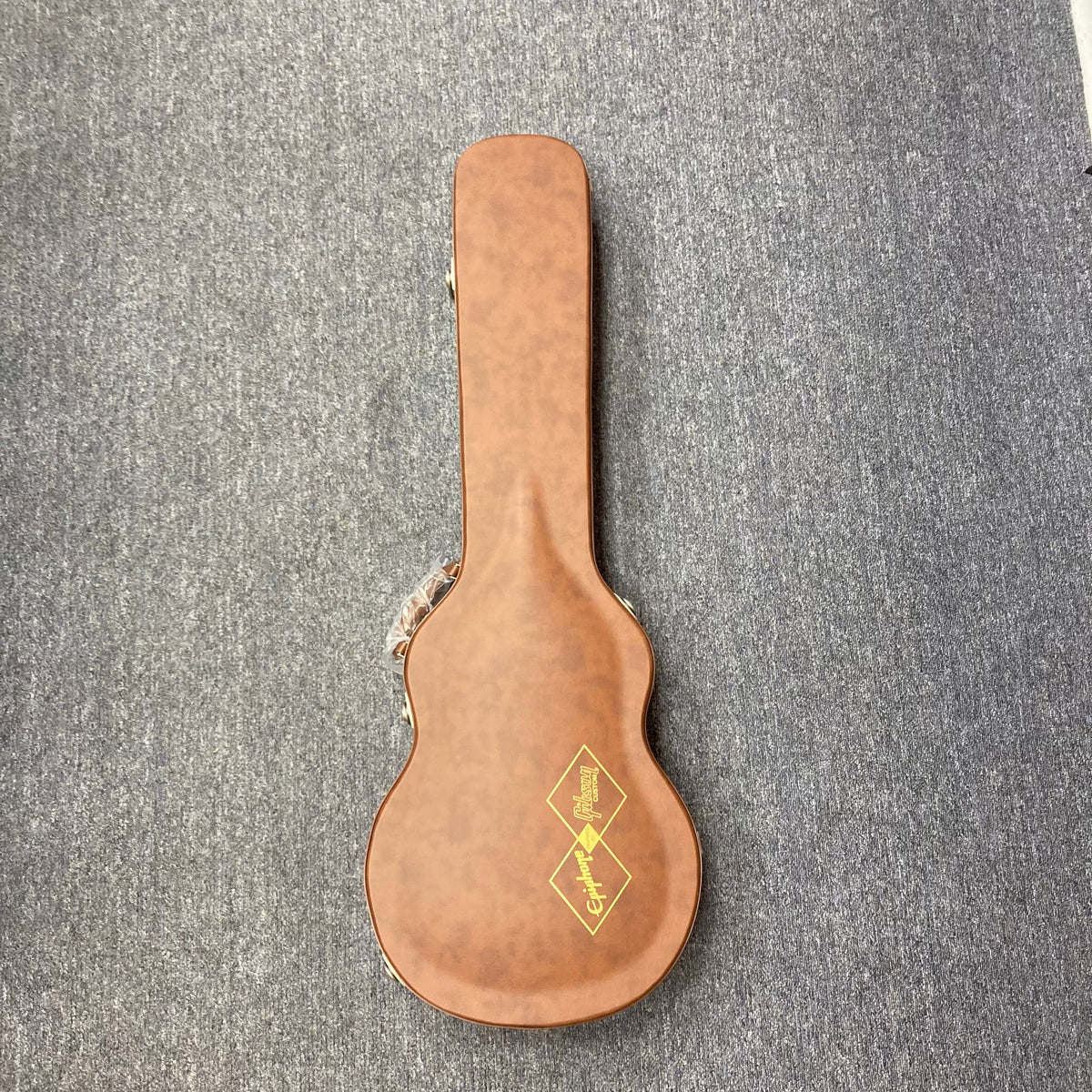 Epiphone 1959 Les Paul Standard Iced Tea Inspired by Gibson, shown in its vintage-style brown hardshell case on a grey carpet.