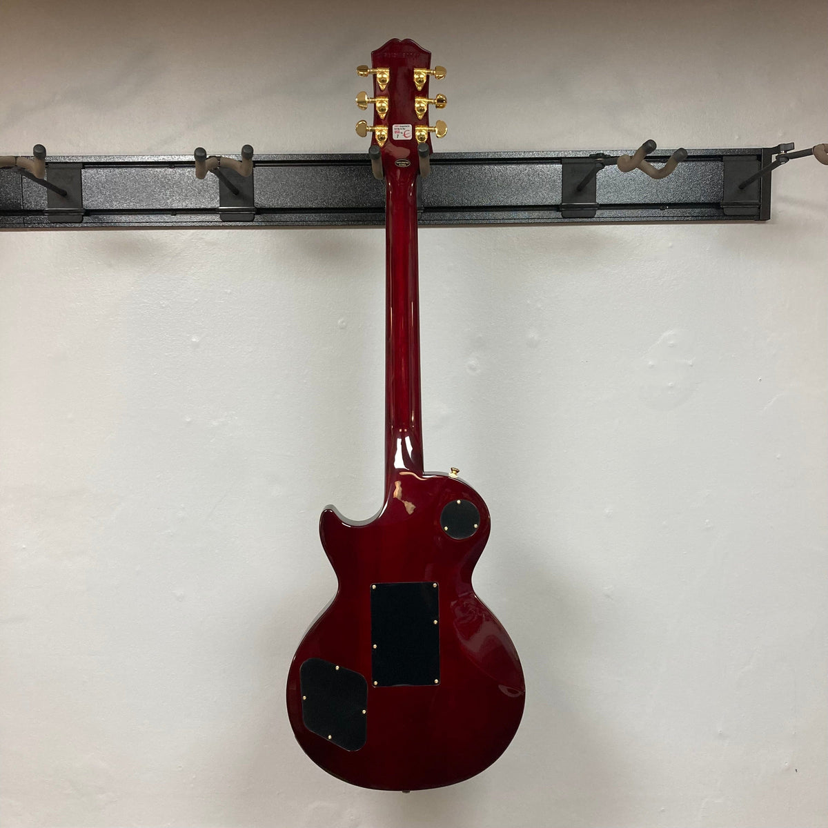 Epiphone Alex Lifeson Les Paul Custom Axcess w/Case, red electric guitar with gold hardware, displayed on a stand.