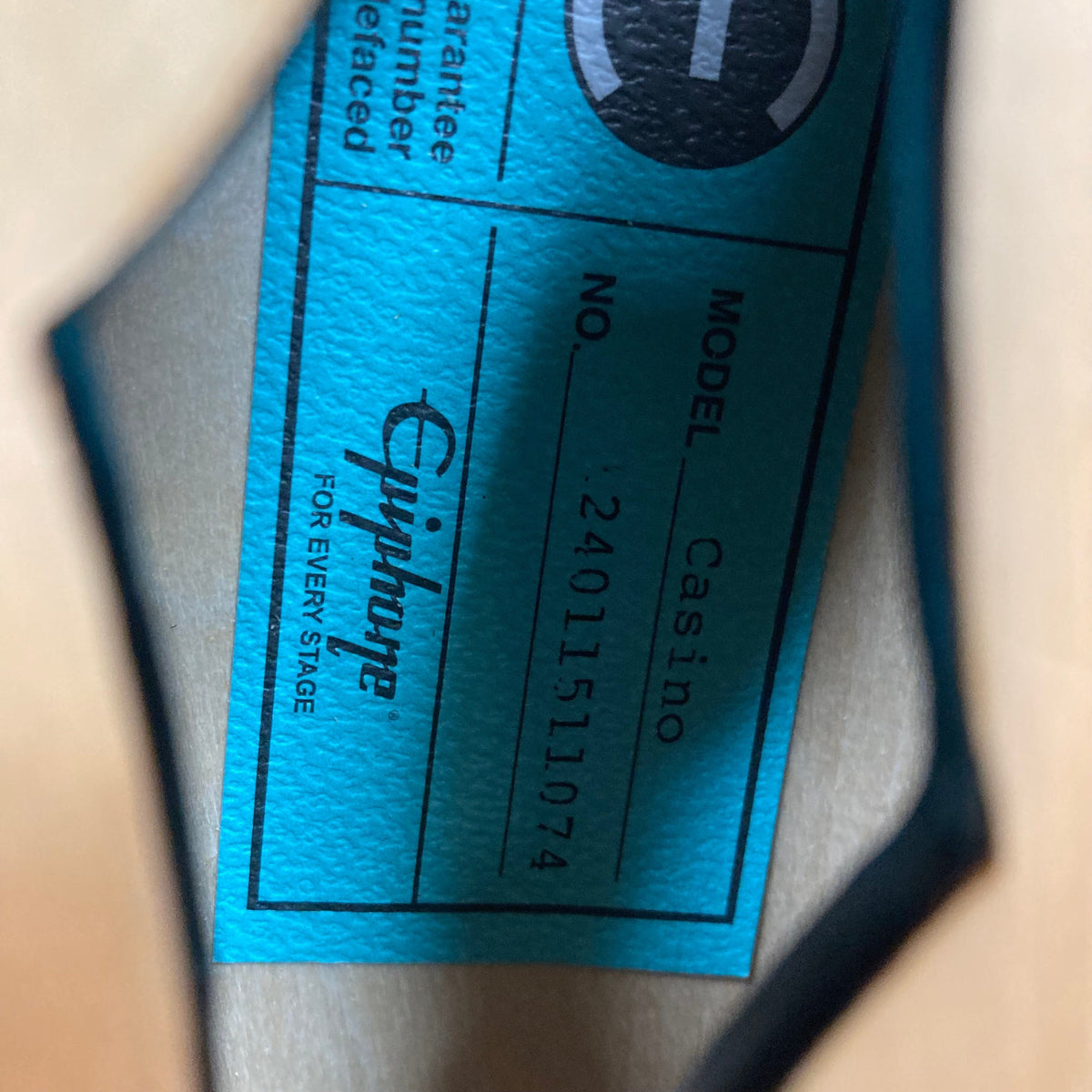 Epiphone Casino Natural guitar with Dogear PRO P-90 pickups displayed on a wooden surface, showcasing its classic design and craftsmanship.